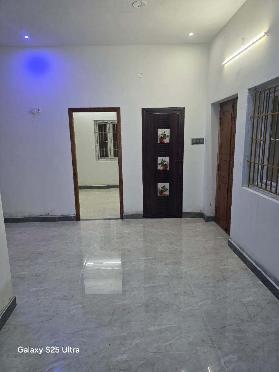 Finished interior at Deeran Nagar with vitrified flooring, painted walls, and flush doors installed.
