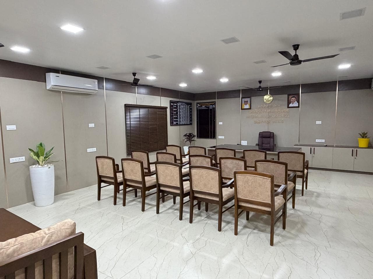 Completed conference hall at the Highway Department office in Thanjavur with upholstered chairs, marble flooring, and recessed lighting.