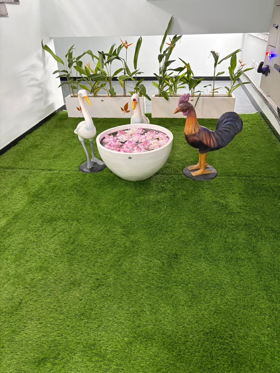 Internal courtyard with artificial turf, a water bowl planter, and the staircase beyond.