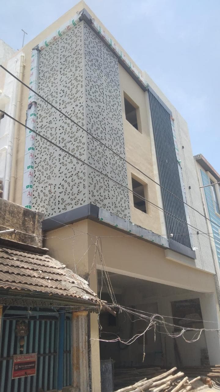 Front facade of the Thanjavur apartment block with the decorative screen panel installed and the balconies plastered.